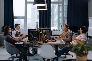 Young professionals collaborating in a vibrant office setting with computers and documents.